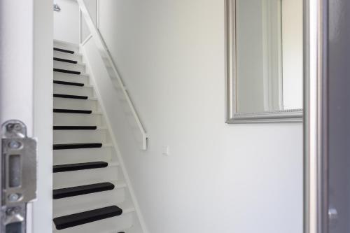 a spiral staircase next to a door with a mirror at Slapen bij Jansz in Kamperland