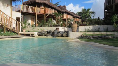 a swimming pool in front of a house at Hurricane Jeri in Jericoacoara