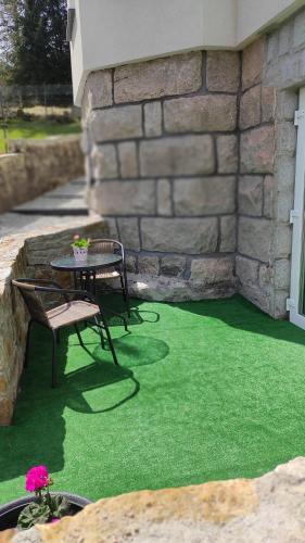 a patio with a table and chairs on green grass at WILLA DobraNocka in Szklarska Poręba