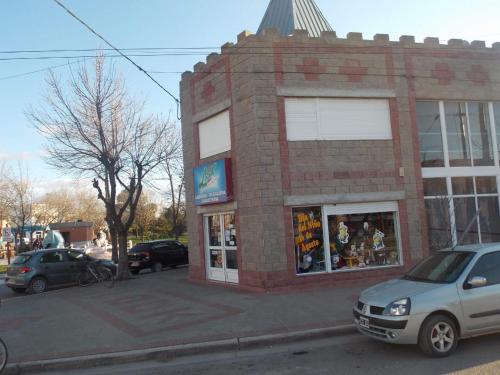 un edificio de ladrillo con un coche aparcado delante de él en Look Departamentos, en Carhué