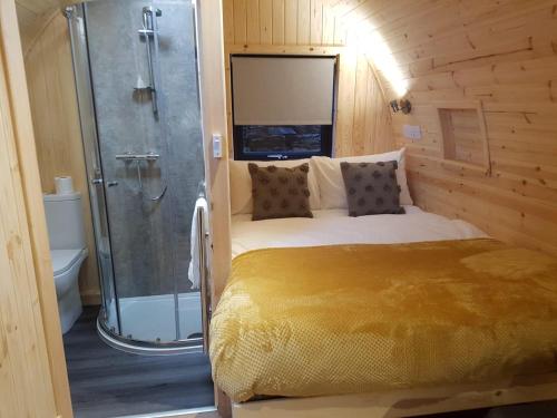 um quarto com uma cama e um chuveiro num quarto em Mallaig Glamping Pods em Mallaig