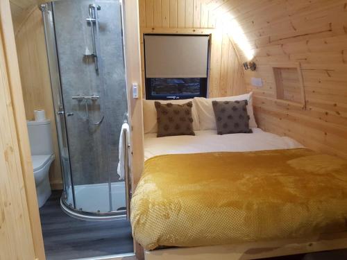 una camera con letto e doccia in una stanza di Mallaig Glamping Pods a Mallaig