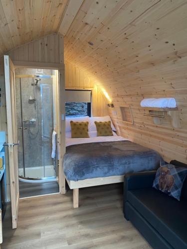 a bedroom with a bed and a shower in a room at Mallaig Glamping Pods in Mallaig