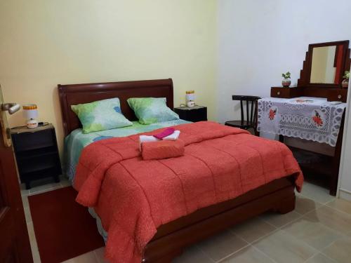 a bedroom with a bed with a red blanket at Le refuge privatif de Julie in Basse-Pointe