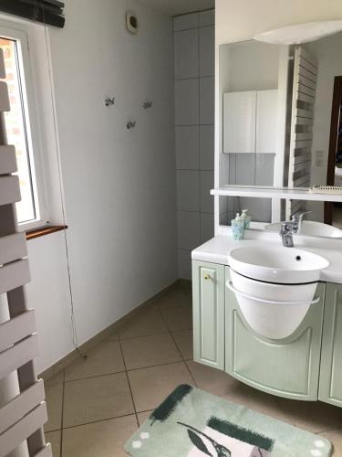 a white bathroom with a sink and a mirror at Pressoir du bois gribout in Hautot-Saint-Sulpice
