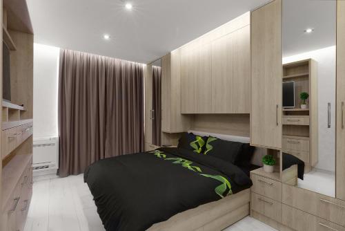 a bedroom with a black bed and a television at Perla Luxury Apartment in Burgas City