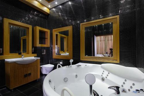 a bathroom with a tub and a sink and mirror at Panoramic 1Br Apartment with Terrace in Arcadia Palace in Odesa