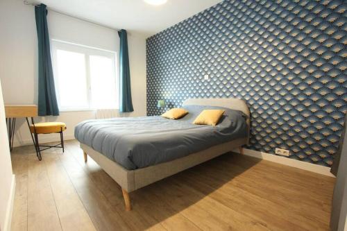 1 dormitorio con cama y pared azul en Appartement centre de Valenciennes entièrement équipé 64m2, en Valenciennes