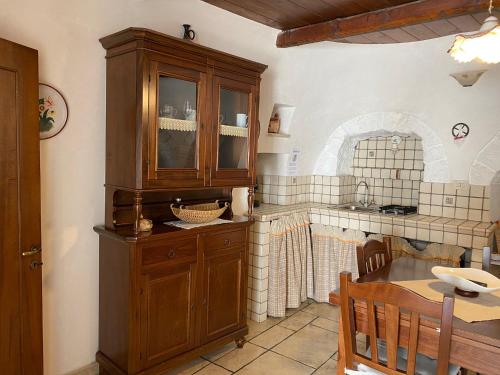 アルベロベッロにあるTrullo Suite Reginaのキッチン(木製のキャビネット、テーブル付)