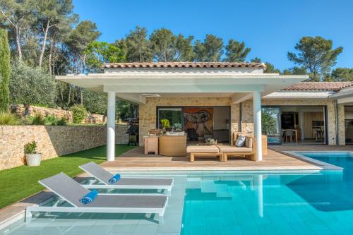 a swimming pool with two lounge chairs next to a house at la villa miel in Opio