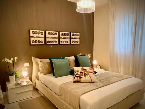 a bedroom with a large bed with green pillows at Villa Luminosa in Torre del Lago Puccini