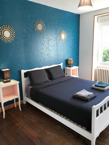 Appartement Guéret في غويريت: غرفة نوم بسرير وجدار ازرق