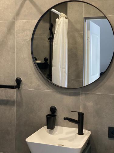 a bathroom with a sink and a mirror at City Ocean apartment in Daugavpils