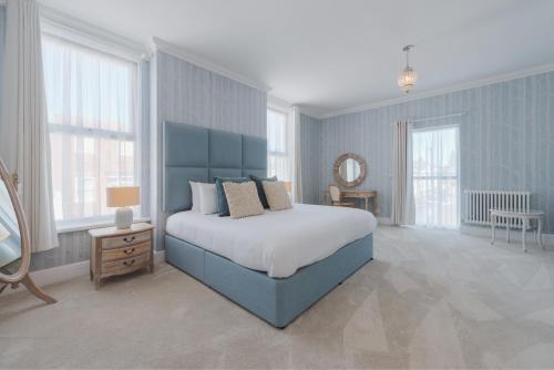 a blue bedroom with a bed and a mirror at Somerset House Boutique Hotel and Restaurant in Portsmouth