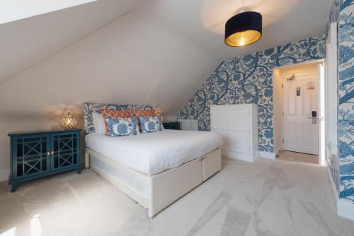 a bedroom with blue and white wallpaper and a bed at Somerset House Boutique Hotel and Restaurant in Portsmouth