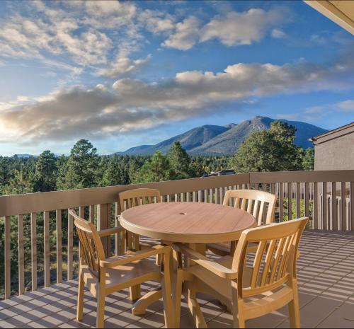 a wooden table and chairs on a balcony with mountains at Club Wyndham Flagstaff in Flagstaff