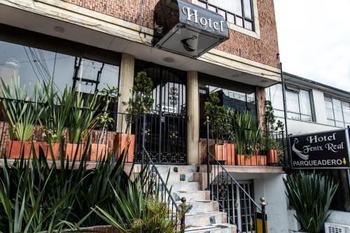 a building with a sign for a hotel with potted plants at Hotel Fénix Real Bogotá in Bogotá