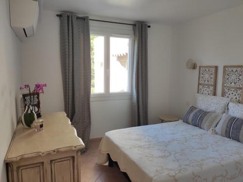 Schlafzimmer mit einem Bett und einem Fenster in der Unterkunft La Ramade de Saint-Tropez in Saint-Tropez