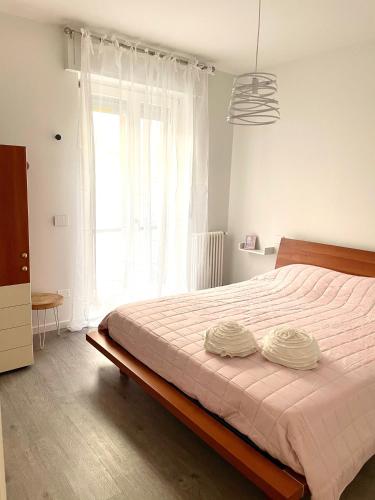 ein Schlafzimmer mit einem Bett mit zwei Kissen darauf in der Unterkunft Appartamento Rosa in Pacengo di Lazise