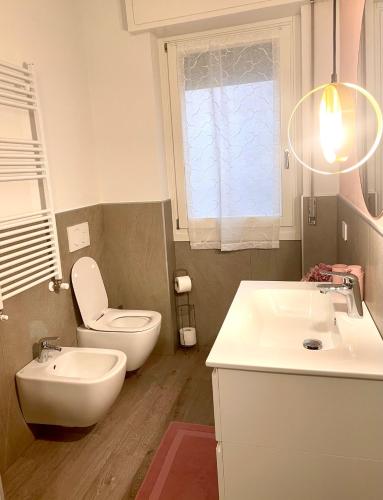 ein Badezimmer mit einem weißen WC und einem Waschbecken in der Unterkunft Appartamento Rosa in Pacengo di Lazise