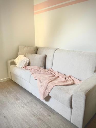 ein Sofa mit einer Decke auf dem Zimmer in der Unterkunft Appartamento Rosa in Pacengo di Lazise
