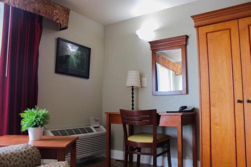 a hotel room with a desk and a table and chair at Stratford Inn in Ashland
