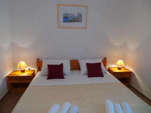 a bedroom with a large bed with two lamps at Apartments in Sabunike/Zadar Riviera 7980 in Batalaži