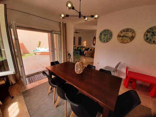 a dining room with a table and chairs and clocks on the wall at Manilva Beach 97 in Manilva
