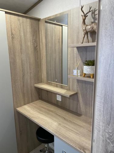a dressing room with a mirror and a stool at Tigers Wood - 2 bed hot tub lodge with free golf, NO BUGGY in Swarland