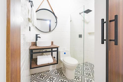 a bathroom with a toilet and a mirror at Ayenda Loft 32 in Medellín