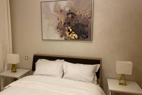 una camera con un letto con due comodini e due lampade di Du Haut Standing au coeur du Parc et Plage à 180 m a Mohammedia