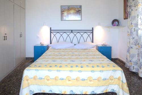 a bedroom with a bed with two blue tables and aintendent at Ritsa House in Ayia Evfimia