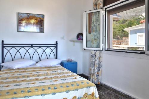 a bedroom with a bed and a window at Ritsa House in Ayia Evfimia