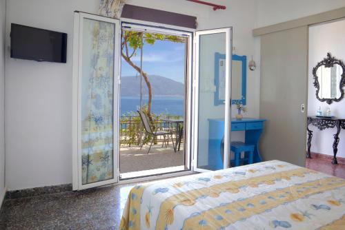 a bedroom with a bed and a view of the ocean at Ritsa House in Ayia Evfimia