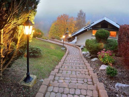 a stone path leading to a house with a street light at Majestic Holiday Home in Untersch nau with Jacuzzi in Unterschönau