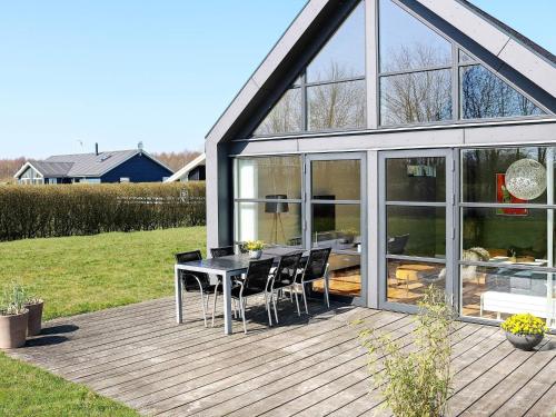 un patio con mesa y sillas en una terraza en 12 person holiday home in Hadsund, en Nørre Hurup