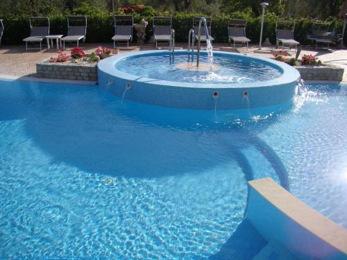 a large swimming pool with a fountain in the middle at Agriturismo I Tesori del Sud Vieste, Puglia in Vieste