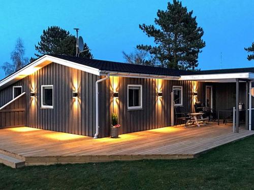 Diernæsにある6 person holiday home in Haderslevのデッキ(照明付)が備わるキャビン