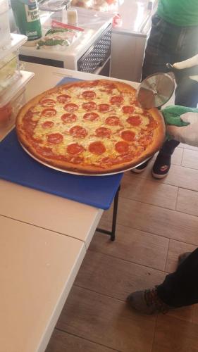 a large pepperoni pizza sitting on top of a counter at Beachfront, Juandolio in Juan Dolio
