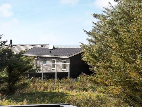 una pequeña casa sentada en la cima de una colina en 10 person holiday home in L kken en Løkken