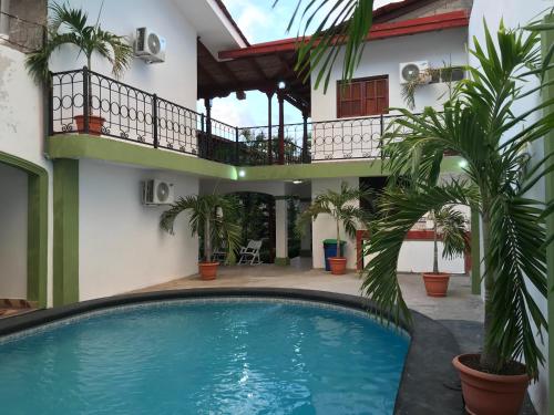 a swimming pool in front of a house with palm trees at Hotel Torogoz in Granada
