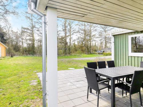 a patio with a table and chairs on a house at 10 person holiday home in Hals in Hou