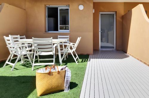 a patio with a table and chairs on the grass at PAPPA casa vacanze in Marina di Ragusa