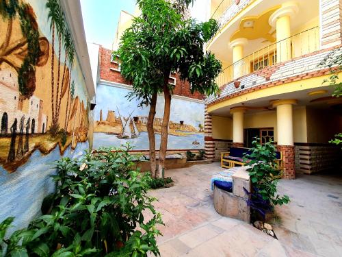 a courtyard of a building with a tree in it at Spring Hotel Luxor in Luxor