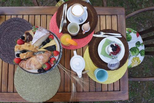a picnic table with a plate of food and a hat at Relais Felciaino B&B in Bolgheri