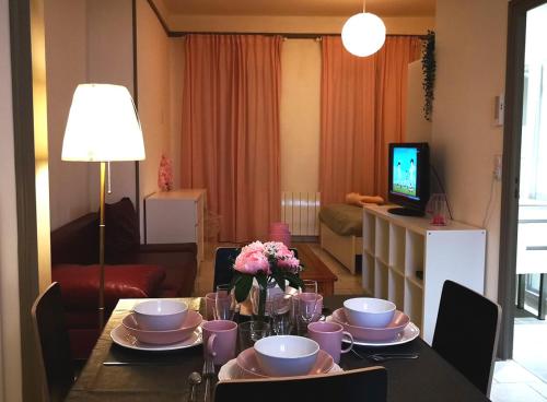a living room with a table with plates and flowers on it at NICE APPARTEMENT in Amboise