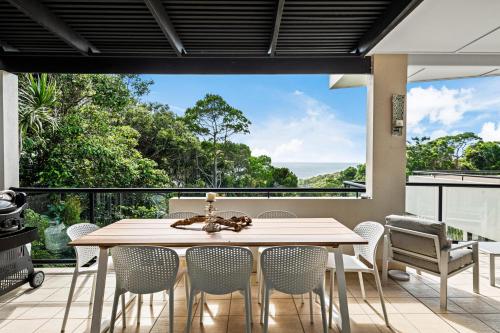 a dining room with a table and chairs on a balcony at Papillon Coolum in Coolum Beach