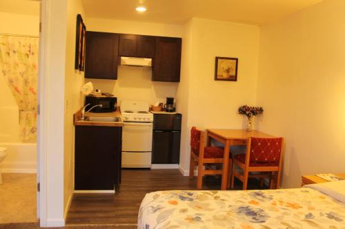 a kitchen with a bed, stove, microwave and refrigerator at Mariners Cove Inn in Westport