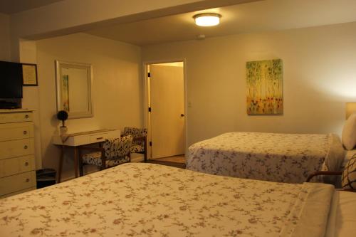 a hotel room with two beds and a desk at Mariners Cove Inn in Westport