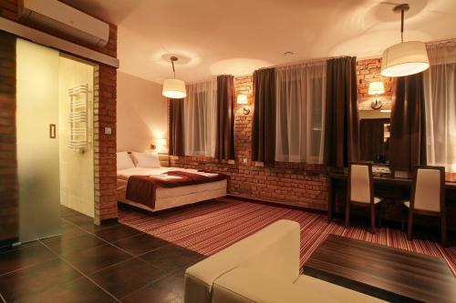 a hotel room with a bed and a table and chairs at Browar CzenstochoviA Hotel&Spa in Częstochowa